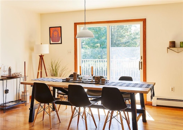 dining area with a baseboard radiator, light hardwood / wood-style flooring, and a wealth of natural light