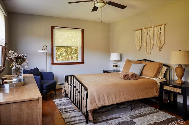 bedroom featuring ceiling fan, dark wood-type flooring, and a baseboard radiator