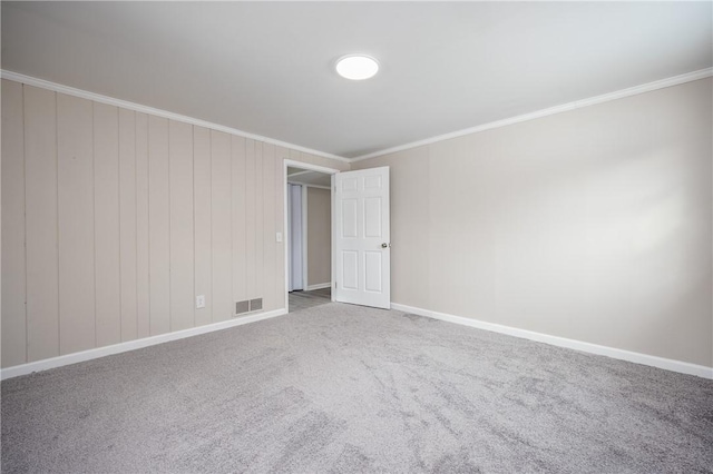 unfurnished room with crown molding and carpet floors