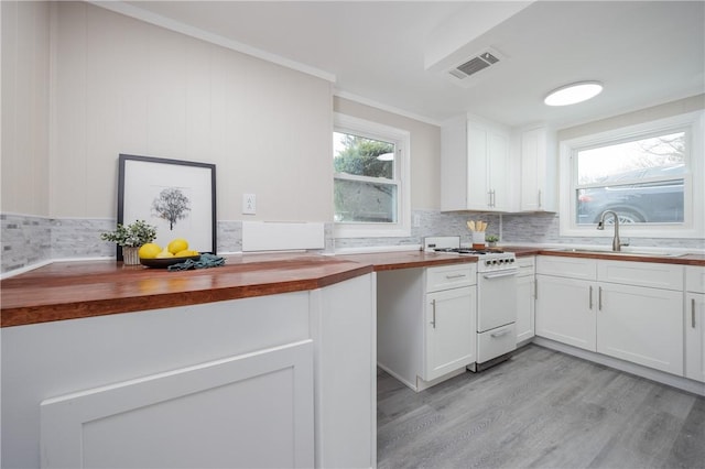 kitchen featuring white cabinetry, white range with gas cooktop, sink, and wooden counters