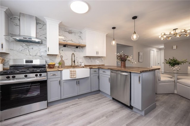 kitchen featuring white cabinetry, appliances with stainless steel finishes, range hood, and gray cabinets