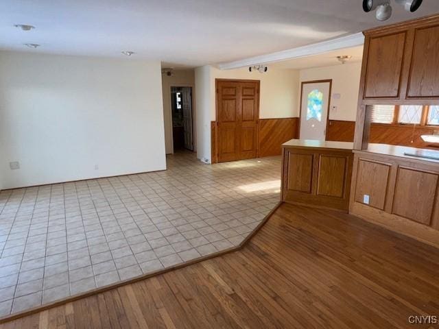 kitchen featuring kitchen peninsula, light hardwood / wood-style floors, and wooden walls