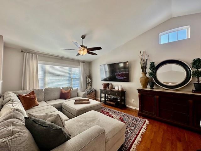 living room featuring ceiling fan, a wealth of natural light, dark hardwood / wood-style flooring, and lofted ceiling