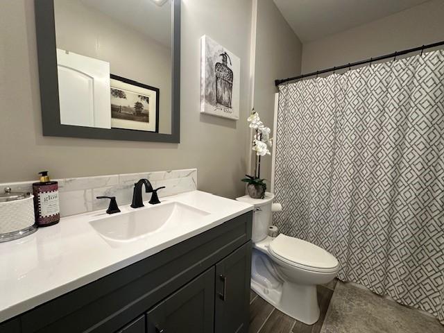 bathroom with vanity, toilet, and wood-type flooring