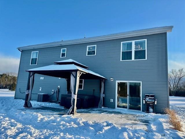 snow covered property with a gazebo and central AC unit