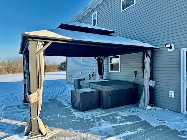 view of patio featuring a wooden deck, a gazebo, and a hot tub