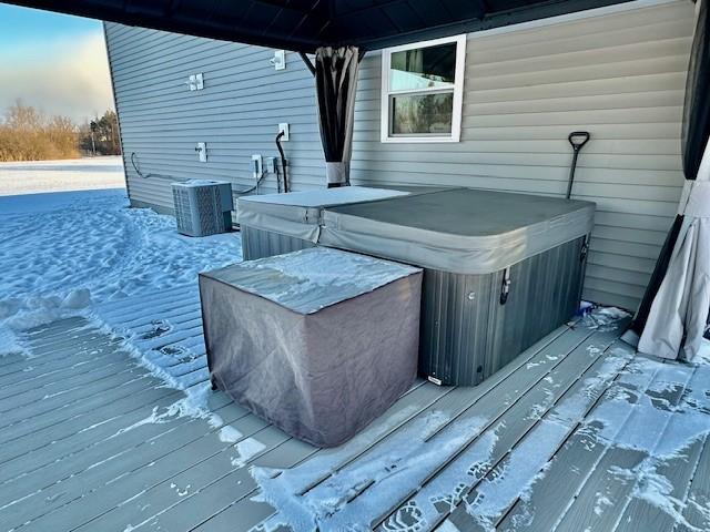 wooden terrace featuring a gazebo, a hot tub, and cooling unit