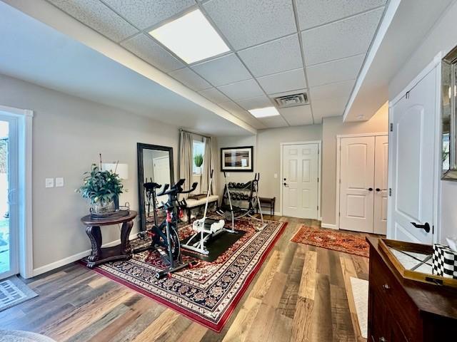 interior space featuring hardwood / wood-style flooring and a drop ceiling