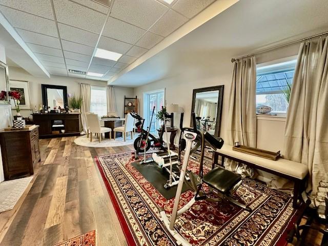 exercise room with hardwood / wood-style floors and a paneled ceiling