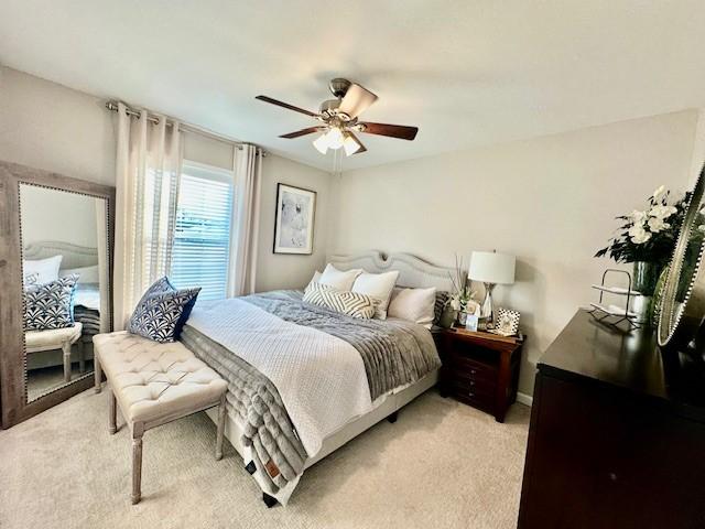 bedroom with ceiling fan and light carpet