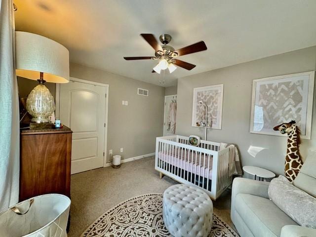 bedroom featuring a crib and ceiling fan