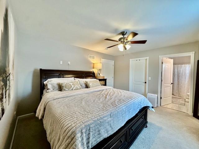 bedroom featuring ceiling fan, ensuite bathroom, and carpet flooring