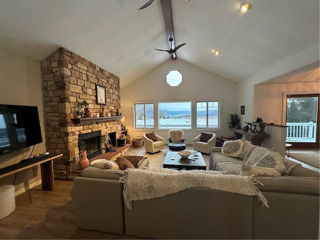 living room featuring lofted ceiling with beams, wood-type flooring, ceiling fan, and a fireplace