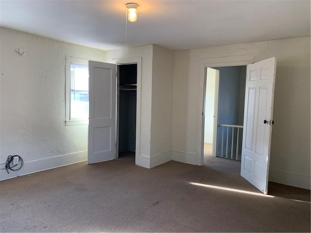 unfurnished bedroom featuring a closet and dark colored carpet