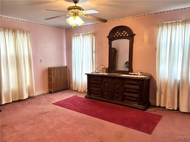 bedroom with ceiling fan, light colored carpet, and radiator