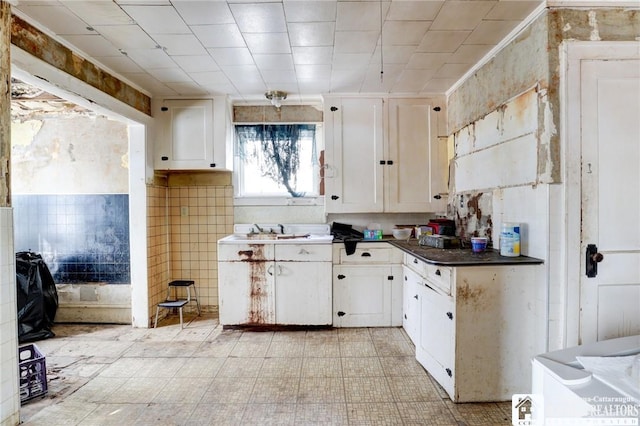 kitchen featuring white cabinetry, sink, and ornamental molding