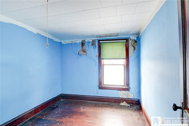 unfurnished room featuring ornamental molding and dark hardwood / wood-style flooring