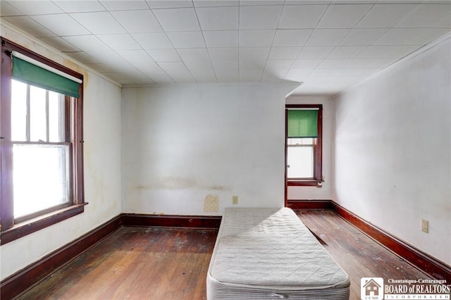 empty room with dark wood-type flooring and a healthy amount of sunlight