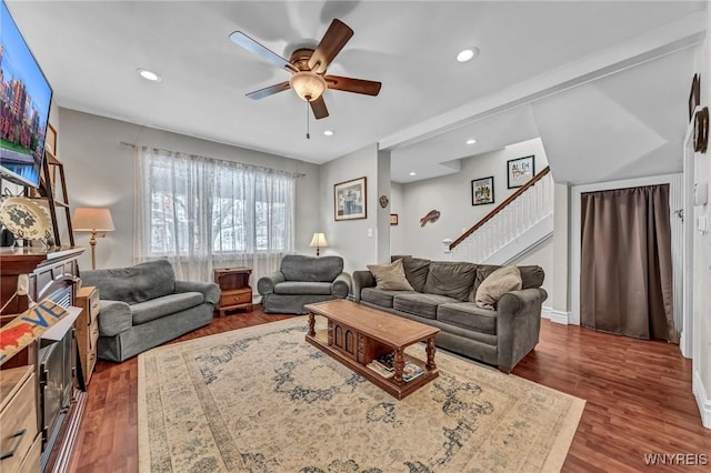 living room with dark wood-type flooring and ceiling fan