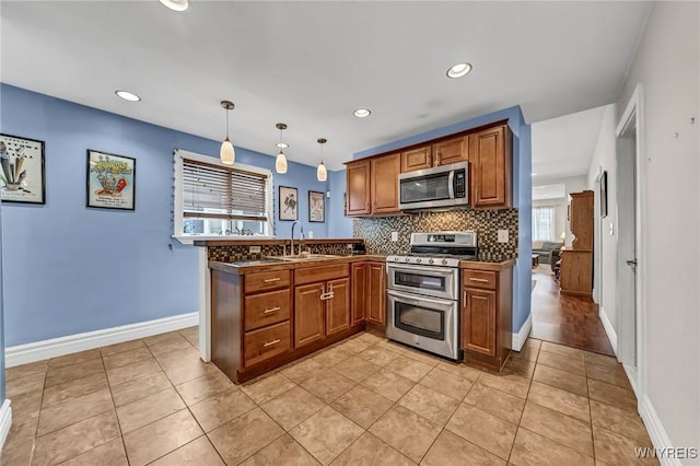 kitchen featuring pendant lighting, sink, backsplash, light tile patterned floors, and stainless steel appliances