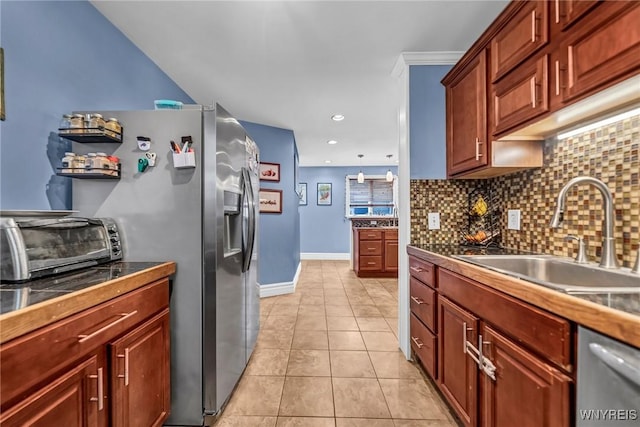 kitchen with appliances with stainless steel finishes, sink, decorative backsplash, light tile patterned floors, and crown molding