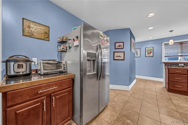 kitchen featuring stainless steel refrigerator with ice dispenser, decorative light fixtures, and light tile patterned floors