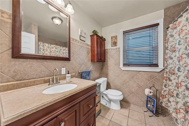 bathroom featuring curtained shower, tile walls, tile patterned flooring, vanity, and toilet