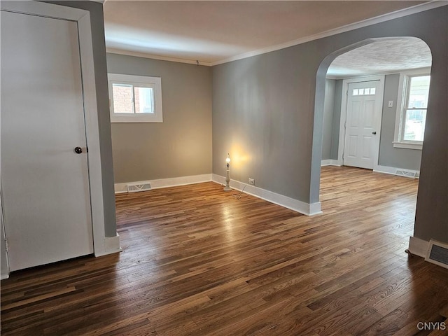 unfurnished room featuring dark hardwood / wood-style flooring, a wealth of natural light, and ornamental molding