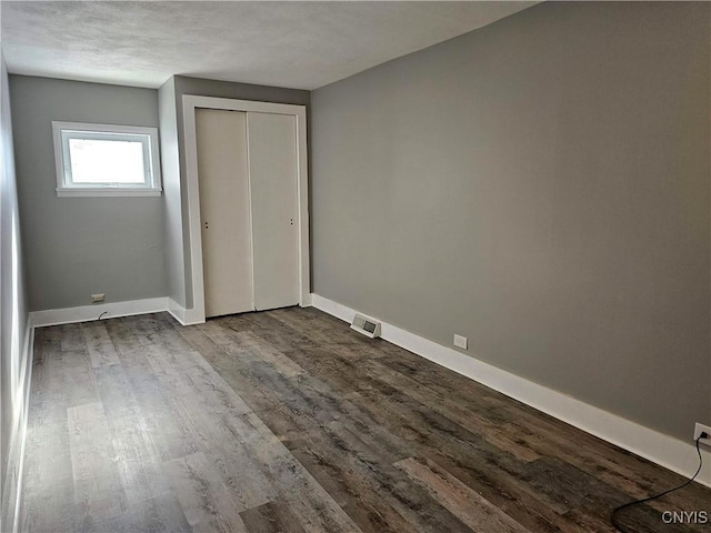 unfurnished bedroom with hardwood / wood-style floors and a closet