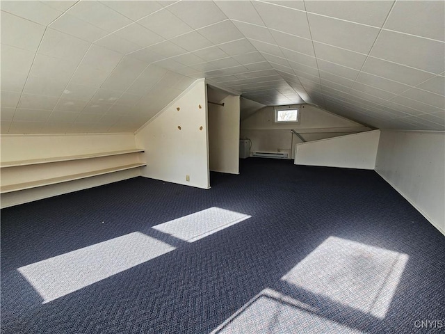 additional living space featuring a baseboard radiator, vaulted ceiling, and dark colored carpet