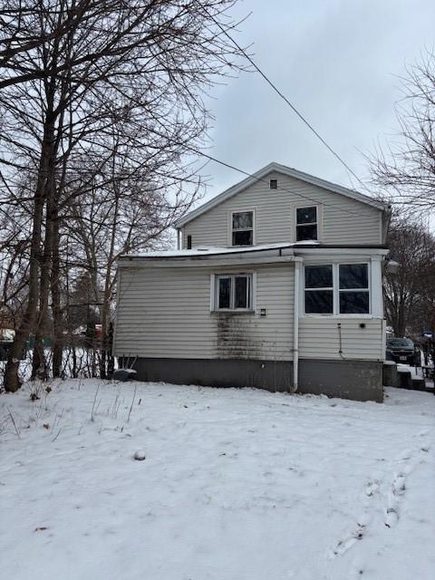 view of snow covered back of property