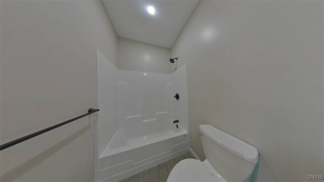 bathroom featuring shower / washtub combination, toilet, and hardwood / wood-style floors