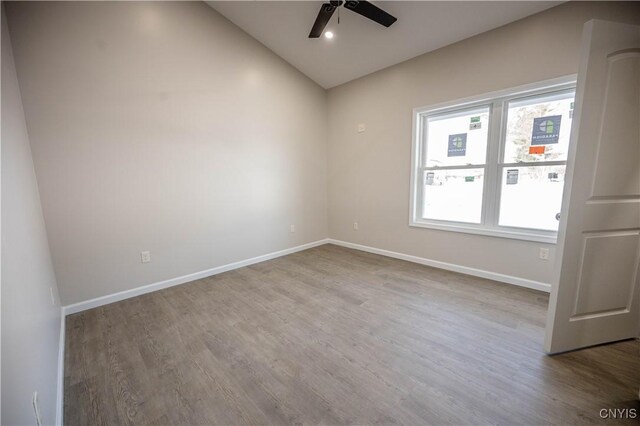 spare room with vaulted ceiling, wood-type flooring, and ceiling fan