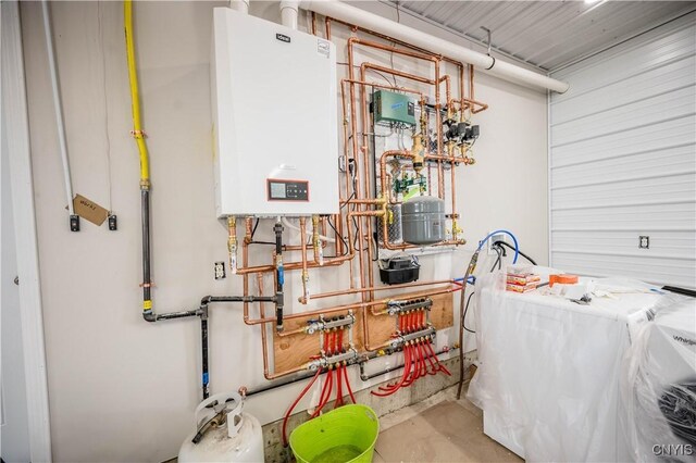 utility room featuring washer / clothes dryer and tankless water heater