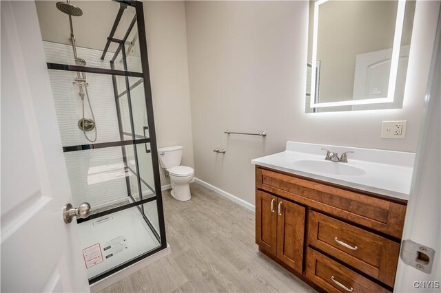 bathroom with vanity, wood-type flooring, toilet, and walk in shower