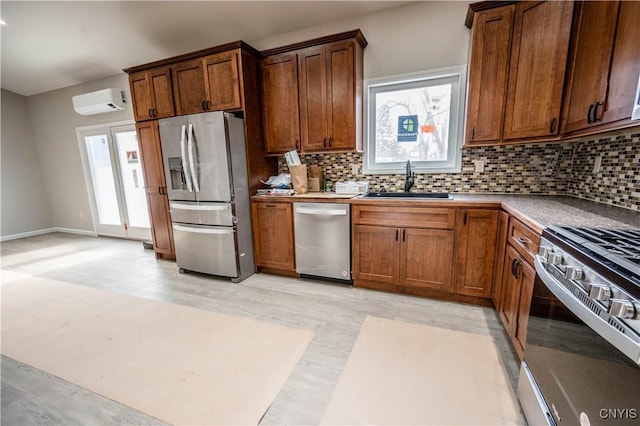 kitchen with sink, a wall mounted AC, light wood-type flooring, appliances with stainless steel finishes, and decorative backsplash