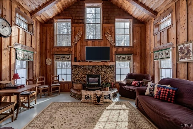 living room with wood ceiling, beamed ceiling, concrete floors, and wood walls