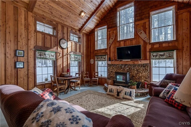 living room featuring high vaulted ceiling, wood walls, wooden ceiling, beamed ceiling, and a wood stove