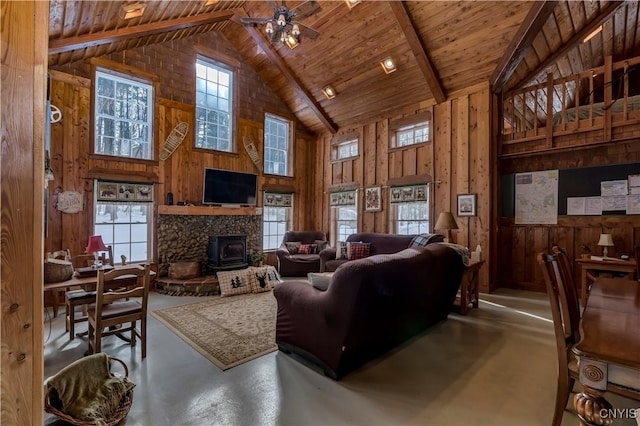 living room featuring high vaulted ceiling, plenty of natural light, wood ceiling, and wooden walls