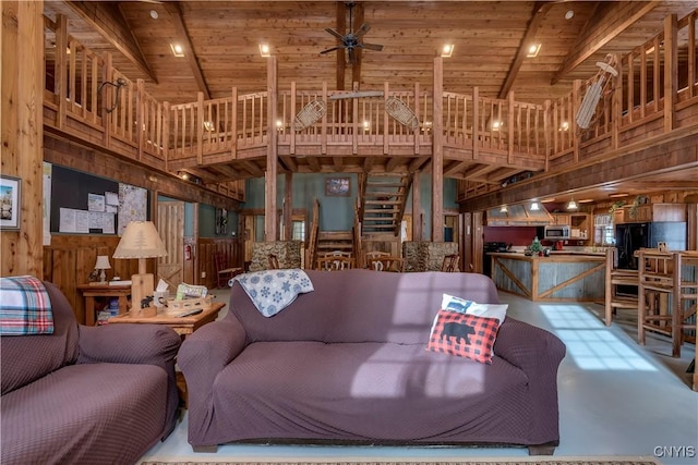 living room featuring beamed ceiling, wooden ceiling, and wood walls