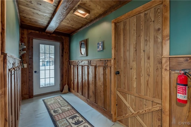 entryway with beamed ceiling, a wealth of natural light, and wooden ceiling