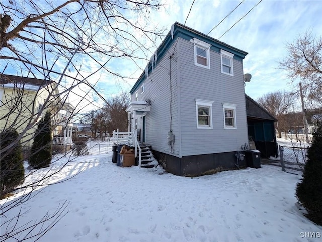 view of snow covered back of property