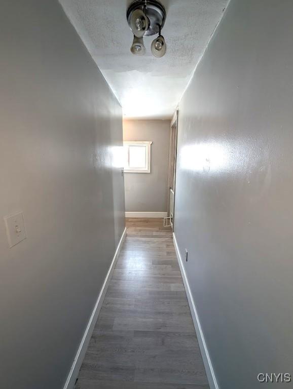 corridor featuring hardwood / wood-style floors and a textured ceiling