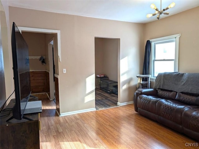 living room featuring wood-type flooring and a notable chandelier