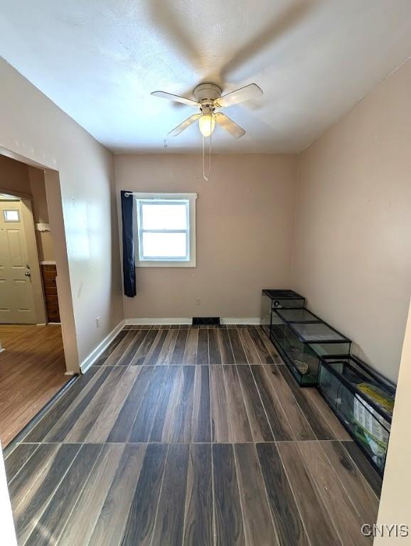 spare room with dark hardwood / wood-style floors and ceiling fan