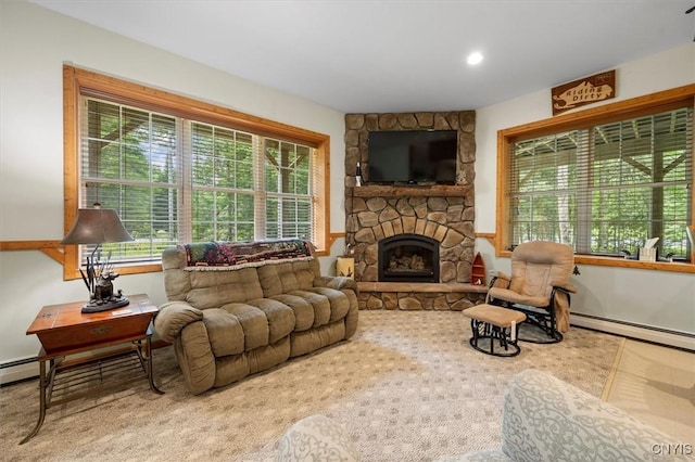 living room featuring a stone fireplace, a baseboard heating unit, and carpet flooring