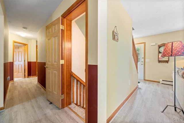 hallway featuring a baseboard heating unit and light hardwood / wood-style floors