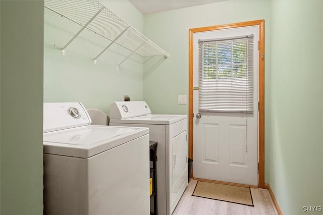 laundry room with washer and dryer and light hardwood / wood-style flooring