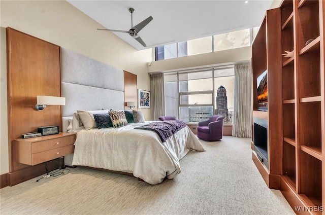 carpeted bedroom featuring a fireplace and ceiling fan