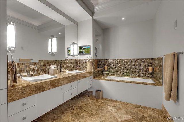 bathroom with tasteful backsplash, vanity, and a tub to relax in